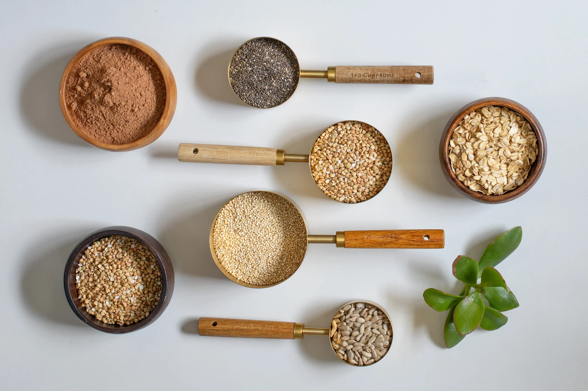 Quinoa, chia, cacao, and almonds on a stone surface.